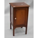 An Edwardian mahogany pot cupboard having open slat back , panelled door, later handle and square