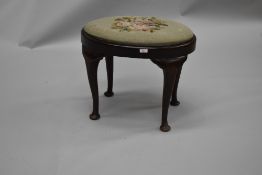 An early 20th Century Queen Anne style dressing table stool , of oval form with drop in