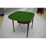 A late 19th or early 20th Century mahogany fold over games table with inlay decoration to frieze, on