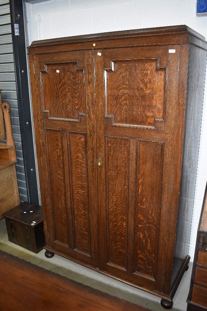 A late 19th or early 20th Century oak wardrobe in the Jacobean style having internal sliding clothes