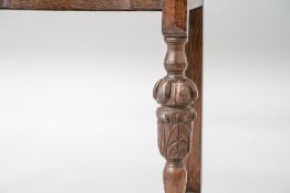 An early 20th Century oak side table having ledge back, shaped front and single frieze drawer, on