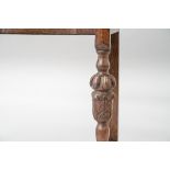An early 20th Century oak side table having ledge back, shaped front and single frieze drawer, on