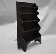 A 19th Century stained frame waterfall bookcase, in the naive style having shaped ends and feet,