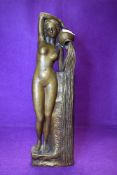 An antique brass cast figure of a nude bather holding water a water jug
