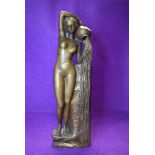 An antique brass cast figure of a nude bather holding water a water jug