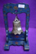 A brass cast Chinese style dinner bell with hand decorated stand