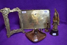 A brass tray having an embossed design, a copper chamber stick and brass photo frame