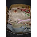 A collection of vintage and antique table linen, embroidered cushion covers and more.