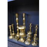 Three sets of brass cast candle sticks also and anchor styled cnadle stick and two mantle urns