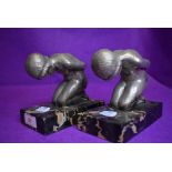 A pair of art deco design book ends or figure sculptures on kneeling maidens metal cast on black