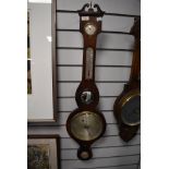 An antique banjo style barometer having a rose wood case and bulls eye mirror