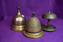 Three desk top brass bell ringers in various forms including bee hive, bell form and art nouveau