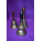 Three vintage hand bells having turned wood handles with brass bell