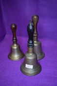 Three vintage hand bells having turned wood handles with brass bell