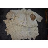 A collection of baby and childrens clothing including fur coat and bonnets, mostly around 1920s.