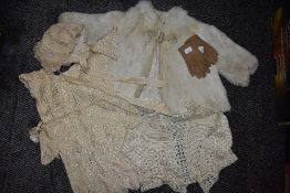 A collection of baby and childrens clothing including fur coat and bonnets, mostly around 1920s.
