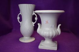 A white glazed mantle urn and a similar vase marked Dartmouth