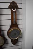 An antique banjo style barometer having an oak case and mercury filled