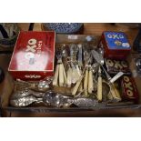 A selection of table wares and cutlery including mother of pearl handled and Oxo cube tins