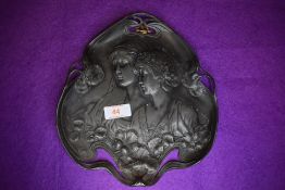 An art nouveau design metal pewter serving tray decorated with lily leaf and portrait design