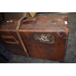 An antique leather suitcase having remnants of labels including LMS.
