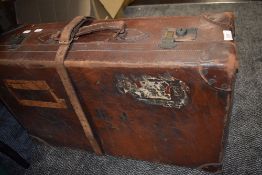 An antique leather suitcase having remnants of labels including LMS.