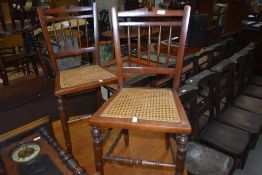 A pair of Victorian mahogany bedroom chairs having cane seats