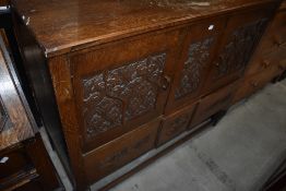 A late 19th or early 20th Century carved oak sideboard of on bulbous legs, ledge back, double