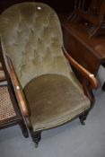 A Victorian mahogany frame button back scroll armchair having turned legs