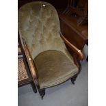 A Victorian mahogany frame button back scroll armchair having turned legs