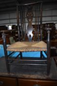 A 19th Century stained fram spindle and wheel back rush seated carver chair