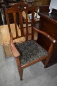 An early 20th Century mahogany carver chair having rail back, roundel decoration to back rail