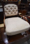 A 19th Century mahogany frame low seat nursing chair with later button back upholstery with