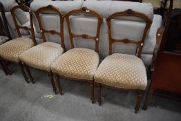 A set of four Victorian Aesthetic salon or dining chairs with later cream upholstery