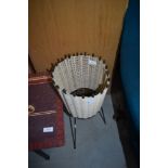 A mid century atomic styled woven plant stand