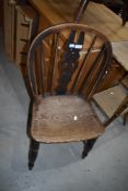 A traditional oak kitchen chair having slat back and turned frame