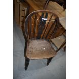 A traditional oak kitchen chair having slat back and turned frame