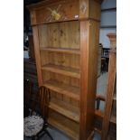 A natural pine tall bookshelf, with carved violin decoration, approx height 214cm, width 101cm