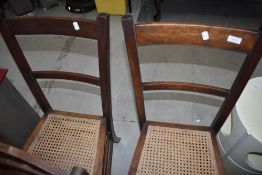 A pair of early 20th Century mahogany rail back bedroom chairs having cane work seats