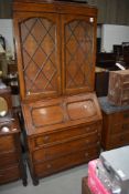 An early 20th Century oak bureau bookcase having lead glazed bookcase section and Jacobean style