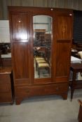 An Edwardian mahogany and inlaid mirror door wardobe on drawer base