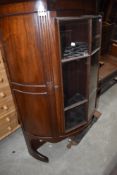 An early 20th Century Regency Revival demi lune bookcase with cupboard base