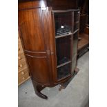 An early 20th Century Regency Revival demi lune bookcase with cupboard base