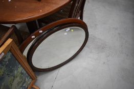 Two early 20th Century mahogany wall mirrors, having oval frames