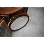 Two early 20th Century mahogany wall mirrors, having oval frames