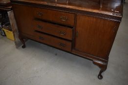 An early 20th Century mahogany sideboard having ledge back and cabriole legs, width approx. 150cm