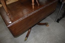 A 19th Century Regency style drop leaf dining table, having frieze drawer, with dummy handle to