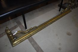 A 19th Century brass ornate fire fender and a pair of complimentary fire dogs