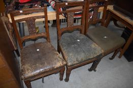 A set of three Victorian oak framed dining chairs having pokerwork and carving to back pabel,