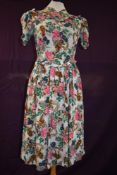 A 1940s floral crepe day dress with ties to waist and side metal zipper.